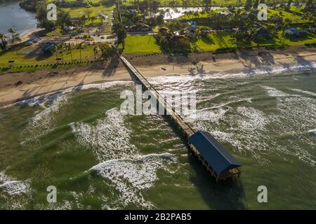 Image panoramique aérienne au lever du soleil au large de la côte au-dessus de la baie Hanalei et de la jetée sur l'île hawaïenne de Kauai Banque D'Images