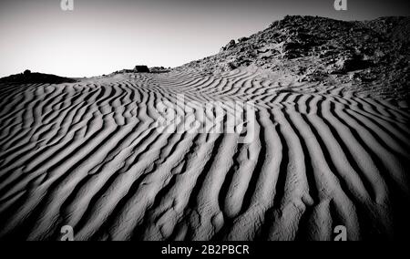 image noir et blanc prise au crépuscule, vue abstraite des ondulations de sable à travers le désert, Banque D'Images