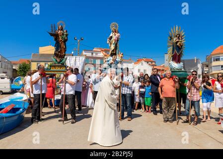 Curé du village et des statues de la Vierge Marie à une procession religieuse dans la région de Corrubedo, Galice, Espagne Banque D'Images