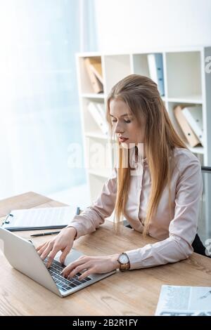 agent de voyage concentré utilisant un ordinateur portable sur le lieu de travail Banque D'Images