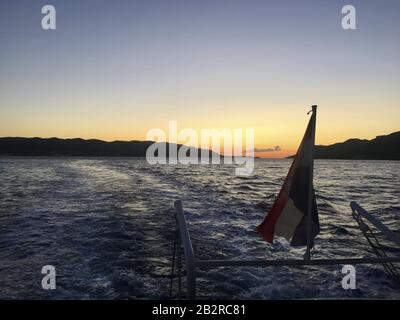 Coucher de soleil d'un bateau à Korčula avec le drapeau croate devant Banque D'Images