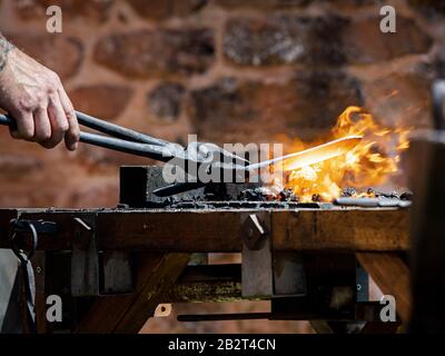 Le forgeron authentique forge le métal sur l'enclume. Traditions médiévales. France Banque D'Images