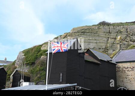 Hastings Angleterre montrant des cabanes de pêche et l'Union Jack voler Banque D'Images