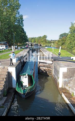 Narrowboat ou bateau de canal passant par une écluse sur le canal de Grand Union, la lune brille au-dessus, Hatton Locks, Hatton, Warwickshire, Angleterre Banque D'Images
