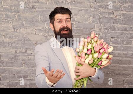 Cadeau romantique. Macho prêt date romantique. Tulipes pour ma chérie. L'homme grand Bow-tie tuxedo tenir fleurs bouquet. Comment être gentleman. Guide pour l'homme moderne. Homme romantique avec des fleurs. Banque D'Images