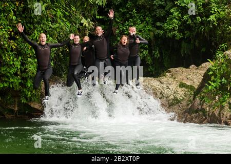 Groupe De Six Personnes Trois Paires De Saut En Même Temps Dans Une Expédition De Canyoning De Waterfall Banque D'Images