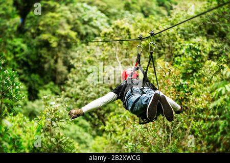 Le Trekker Masculin Mûr Porte Des Vêtements Informels Sur Ziplin Ou Canopy Experience Dans La Forêt Tropicale Équatorienne Banque D'Images
