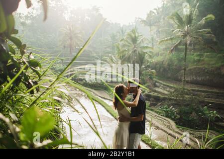Jeune couple d'Amérique latine avec la vue étonnante de Ubud rizières en terrasse le matin. Heureux ensemble, de miel à Bali. Style de voyage.