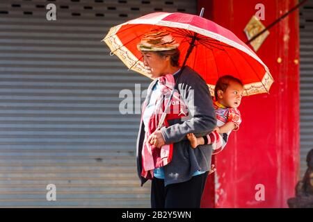 Mae Sai, Thaïlande - 29 novembre 2011 : une femme et un enfant birman à caractère ethnique franchissant la frontière. Il s'agit d'un poste frontalier occupé. Banque D'Images