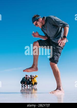 Touristes à Uyuni Salt Flats (Espagnol: Salar de Uyuni ) en Bolivie, Amérique du Sud, perspective forcée. Banque D'Images