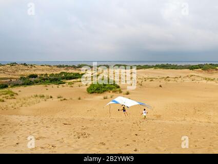 L'étudiant se prépare à atterrir avec un instructeur de l'école de voile Kitty Hawk Kites Hang sur les dunes de sable Banque D'Images