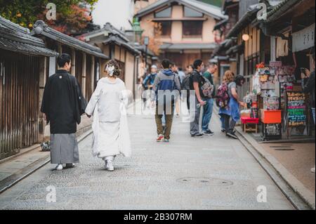 Un couple japonais le jour de leur mariage vêtu de kimono traditionnel prenant des photos à kyoto Banque D'Images