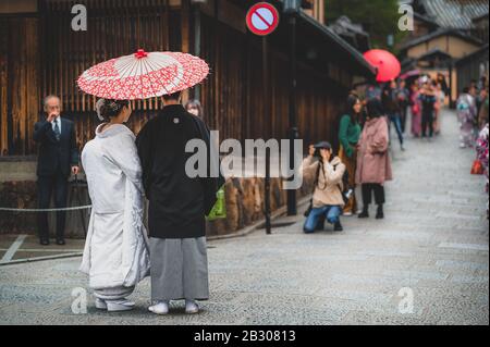 Un couple japonais le jour de leur mariage vêtu de kimono traditionnel prenant des photos à kyoto Banque D'Images