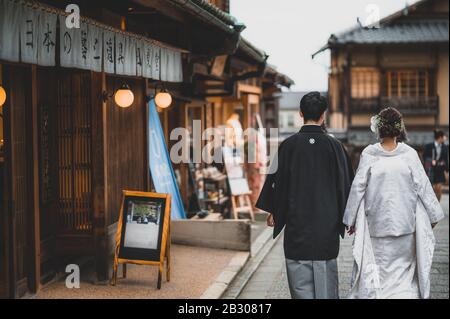 Un couple japonais le jour de leur mariage vêtu de kimono traditionnel prenant des photos à kyoto Banque D'Images