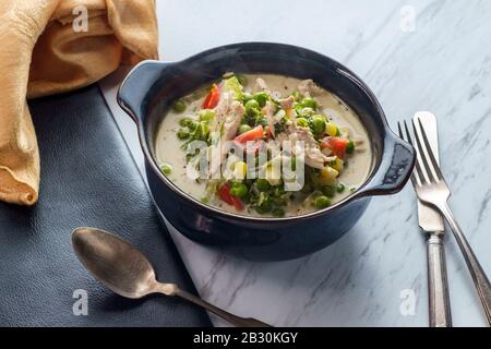 Sauce blanche au poulet fricassee à la cuisse de poulet cuit lentement britannique avec des légumes colorés Banque D'Images