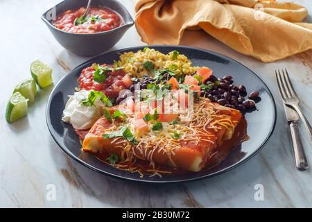 Authentique chimichanga burrito mexicain avec riz à la crème aigre et haricots noirs Banque D'Images