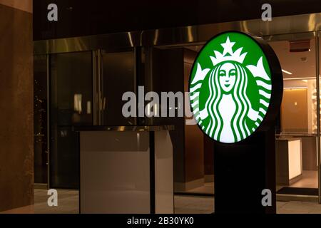 Le logo Starbucks Coffee s'est éclairé la nuit devant un café à l'intérieur d'un hôtel. Banque D'Images