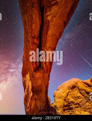 Le ciel nocturne et la voie laiteuse au-dessus de la délicate Arc de Sandstone de l'Arc de fenêtre Nord, l'une des nombreuses grandes Arches de Sandstone dans le parc national d'Arches Banque D'Images