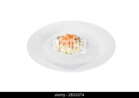 Salade russe avec poisson rouge, saumon kéta, œufs, concombres, carottes, pommes de terre sur plaque, vue latérale fond blanc isolé Banque D'Images