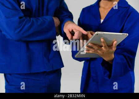 Ingénieurs se tenant avec une tablette numérique sur fond blanc Banque D'Images