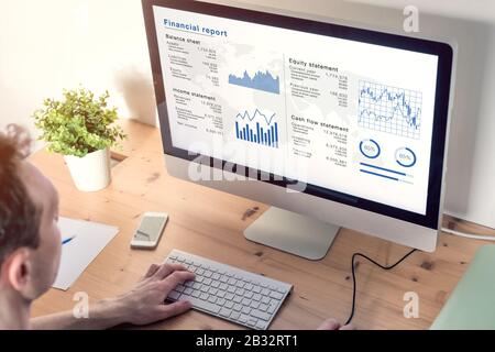 Comptable analyse du rapport financier sur écran d'ordinateur au bureau, document d'affaires avec des données telles que le bilan, les états de revenu et de capitaux propres, c Banque D'Images