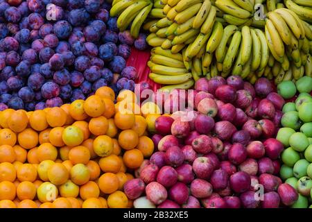 Vue de dessus sur les oranges, les pommes rouges et vertes, les bananes et les prunes chez 'Mercado dos Lavradores', marché local à Funchal, île de Madère, Portugal Banque D'Images