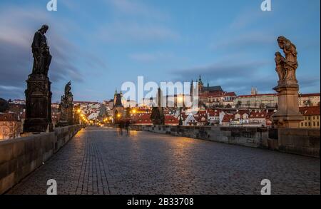 Vide, moody Charles Bridge à Prague juste avant le lever du soleil. Vue sur le château de Hradcany et ses statues sur le pont médiéval Banque D'Images