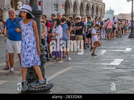 Jeune fille en ligne. Files d'attente, tourisme de masse, place St Marc, Venise, Italie Banque D'Images