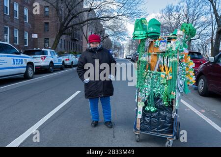 Une femme de l'Équateur qui vend des chapeaux verts et des perles pour les marcheurs à porter lors de la Saint-Patricks Day pour Tous les défilés à Sunnyside, Queens, New York City. Banque D'Images