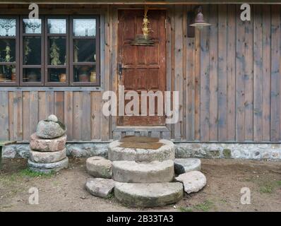 De grandes pierres de granit près de l'ancienne porte de la grange ruarale pour le stockage du bois de chauffage et des outils agricoles. Collage panoramique à partir de plusieurs prises de vue en extérieur Banque D'Images