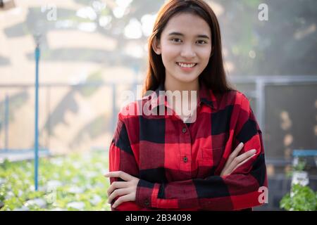 Femme asiatique souriante agriculteur en serre hydroponique bio.petit entrepreneur d'affaires et ferme de légumes biologiques et concept de nourriture saine Banque D'Images