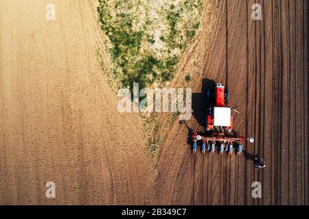 Fermier et tracteur avec seeder de drone pov, vue aérienne de la préparation d'agronome à l'ensemencement des machines, vue du dessus Banque D'Images