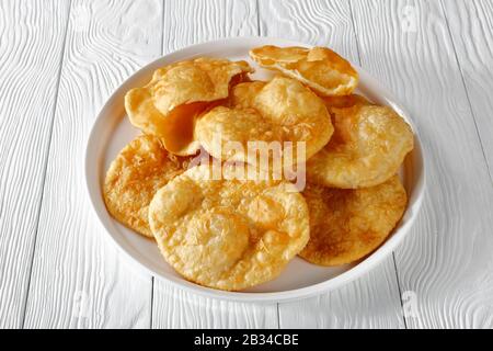 Gros plan de Bhatura, pain sauté frit indien sur un plateau blanc sur une table en bois, vue horizontale d'en haut, espace libre Banque D'Images