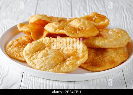 Gros plan de Bhatura, pain indien au levain frit sur un plateau blanc sur une table en bois, vue horizontale d'en haut Banque D'Images