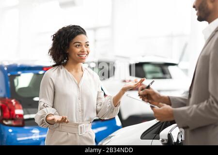 Un Client De Dame Joyeuse Qui Parle Avec Le Vendeur Automatique À La Concession Banque D'Images