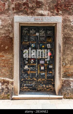 Graffitis sur une ancienne porte peinte à Venise, Italie Banque D'Images