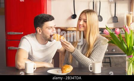 Adorable couple amoureux partageant le petit déjeuner ensemble dans la cuisine Banque D'Images