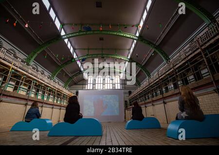 Les membres de l'installation d'art réfléchissant spéculaire à Moseley Road Baths, Birmingham, qui présente des animations peintes à la main créées par 500 personnes locales en collaboration avec la National Trust. Banque D'Images