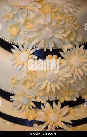 gâteau de mariage à deux niveaux avec rubans bleus et fleurs givrantes décorant le gâteau de mariage Banque D'Images