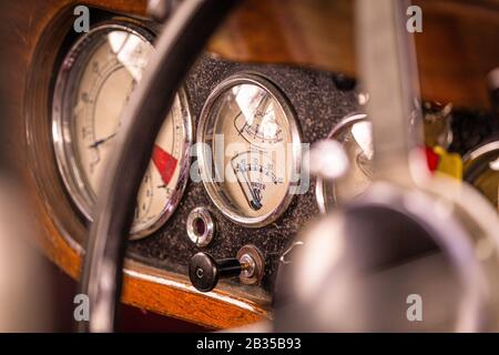 L'intérieur d'une ancienne voiture britannique Classic se concentrant sur les cadrans intérieurs indiquant la vitesse, le levier du starter, les niveaux de carburant et la température de l'eau, Banque D'Images