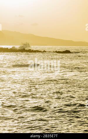 Marée et vagues venant en direction de Punta Brava sur la plage pendant un calima à Playa jardin, Puerto de la Cruz, Tenerife, îles Canaries, Espagne, Banque D'Images