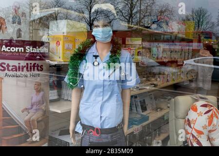 Alors que la pandémie de coronovirus se tient dans tout le Royaume-Uni, 53 cas maintenant signalés par les autorités sanitaires, la fenêtre d'une entreprise d'équipements médicaux dans le sud de Londres, un masque chirurgical est porté par un mannequin d'infirmière, le 4 mars 2020, à Londres, en Angleterre. Banque D'Images