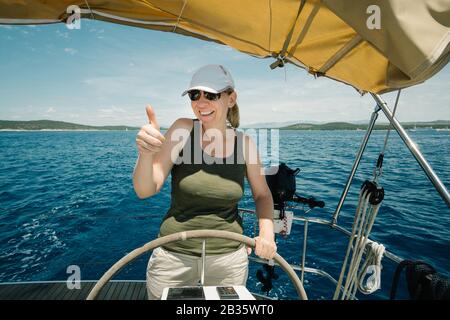 Skipper femelle sur le volant d'un yacht. Concept de voile et de yachting. Banque D'Images