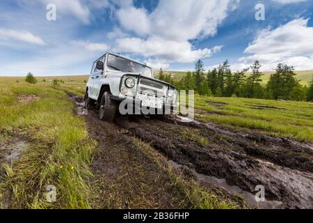 Mongolie, province de Khovsgol, steppe près de Khatgal, jeep russe UAZ 469 sur une piste boueuse Banque D'Images