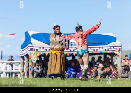 Mongolie, province de Khovsgol, Tsagauannur, festival de Naadam, tournoi de lutte, entraîneur, zasuul en mongol, et lutteur exécutant la danse rituelle de faucon avant le match Banque D'Images