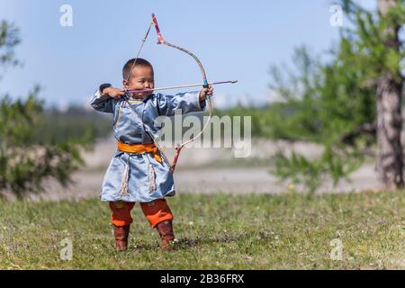 Mongolie, province de Khovsgol, Khatgal, festival de Naadam, jeune garçon dans des vêtements traditionnels pratiquant le tir à l'arc Banque D'Images