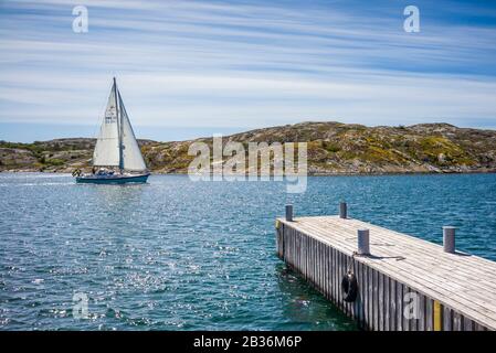 Suède, Bohuslan, Orust Island, Mollosund, jetée et bateau à voile Banque D'Images