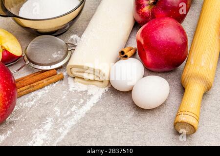 Concept de cuisson des ingrédients de tarte aux pommes. Pommes fraîches à la cannelle, farine, sucre, œufs. Cuisson sur fond de pierre, gros plan. Banque D'Images