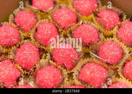 Gros plan de délicieuses bonbons à la noix de coco granulée avec du sucre de cristal rose. Bonbons typiques pour l'anniversaire des enfants brésiliens. Bonbons faits à la main pour un anniversaire. S Banque D'Images