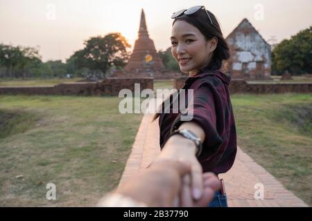 Suivez-moi jusqu'au temple, ayutthaya thaïlande. Femme touristique menant petit ami au temple thaïlandais. Concept de voyage de personnes. Banque D'Images